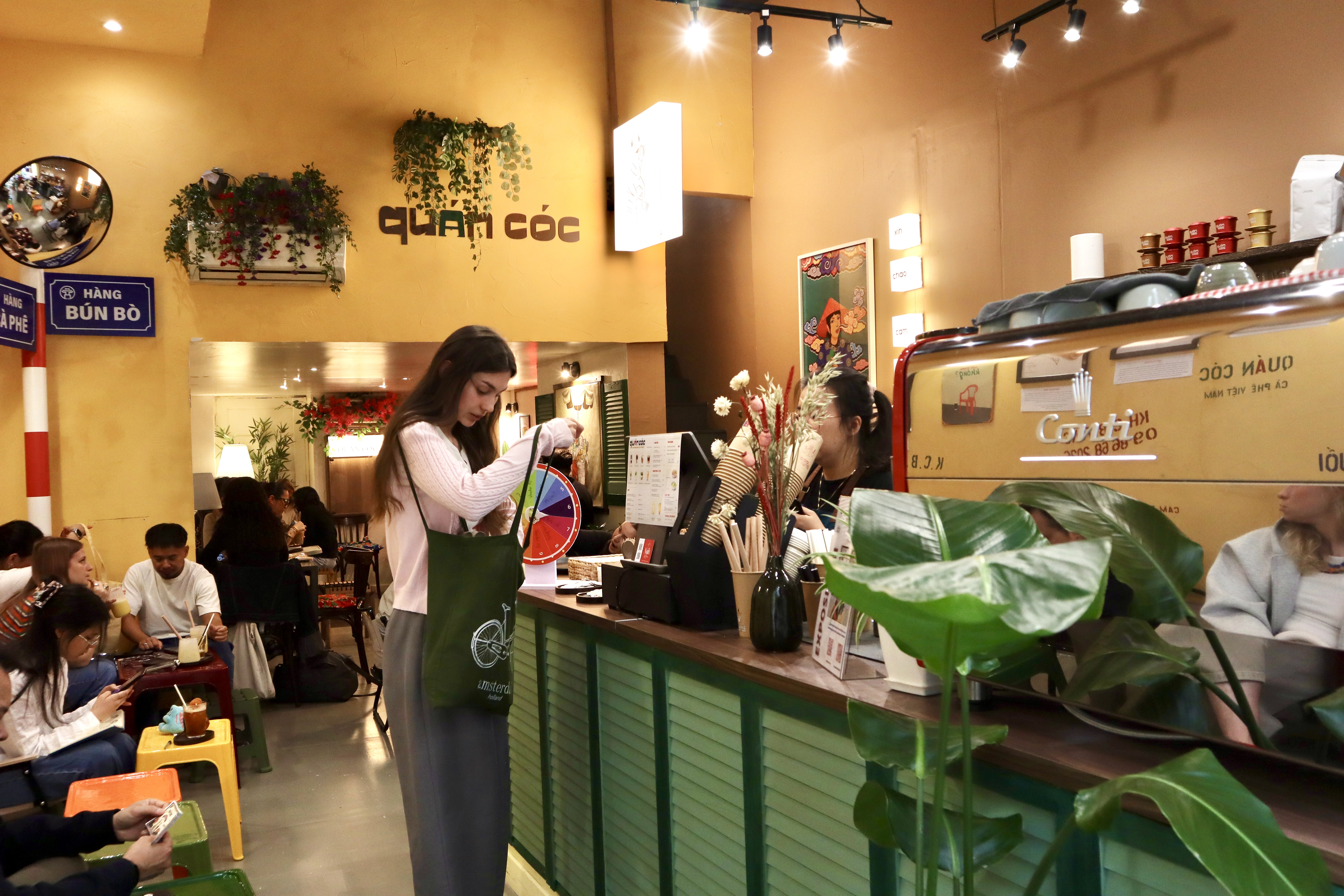 Le comptoir vert de Quán Cóc et les clients dans une ambiance chaleureuse