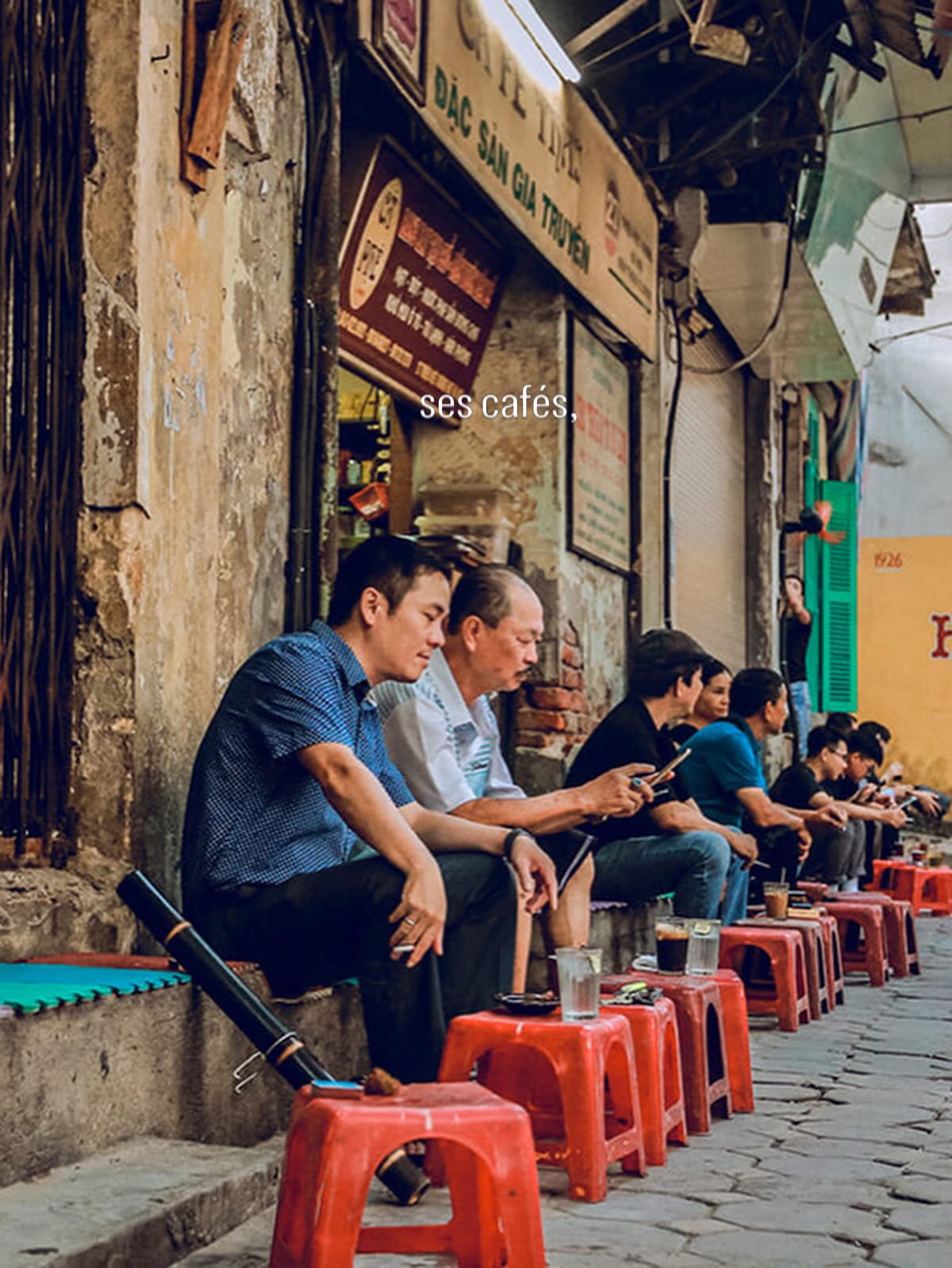 Des clients assis sur de petits tabourets devant un café vietnamien